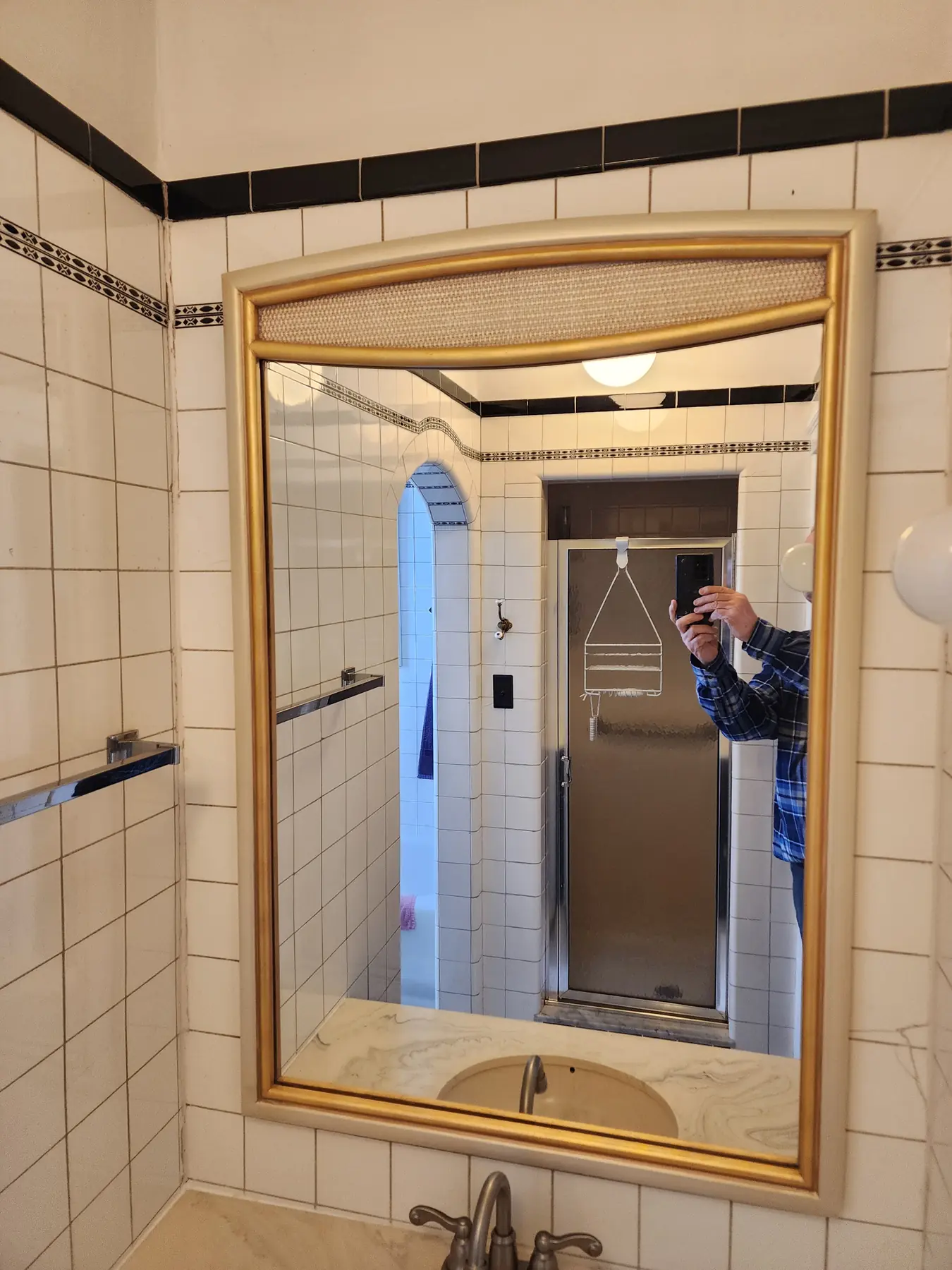 Gold leaf gilded mirror in a tiled bathroom